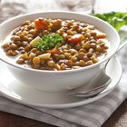 Bay leaf, chickpea, green pea, lentil and spoon on chopping board, close-up