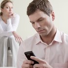 Male office worker with feet on desk, woman leaning on edge of desk