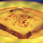 A close-up of a piece of lasagna and some breadsticks