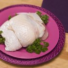 Raw chicken leg on cutting board on wooden background