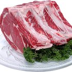 Butcher cutting beef meat on a wooden table