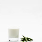 Iced coffee with pouring milk in glass