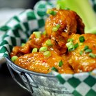different flavored chicken wings on wooden table