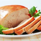 Couple basting thanksgiving turkey