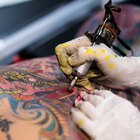 Tattooer concentrating on giving someone a tattoo