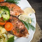 Baked salmon garnished with asparagus and tomatoes with herbs