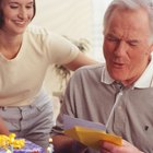 portrait of an elderly man holding up a present for a birthday celebration