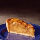 Apple pie with cut slice on rustic wood