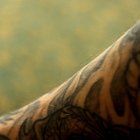 Tattooer concentrating on giving someone a tattoo