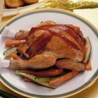 Couple basting thanksgiving turkey