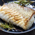 Baked salmon garnished with asparagus and tomatoes with herbs