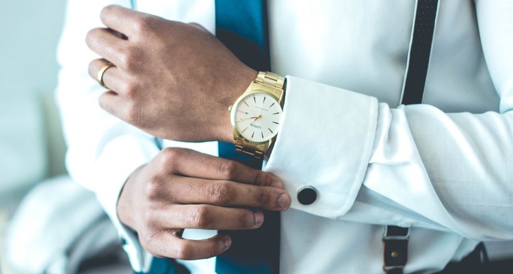 Adjusting cufflinks on starched white shirt.