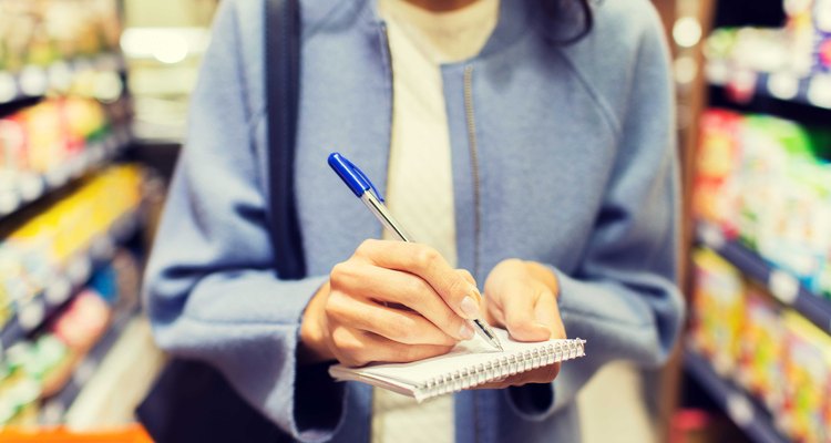 Woman uses checklist at grocery store.