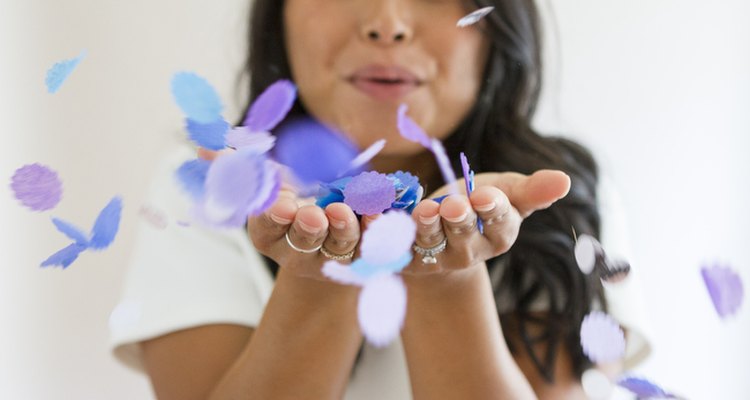 Girl blowing confetti.