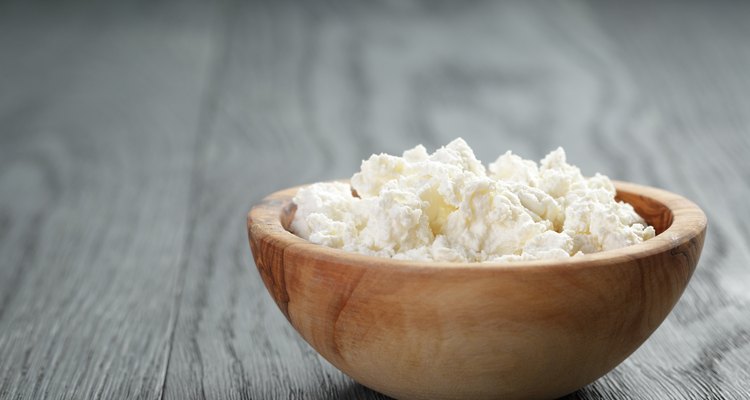 fresh ricotta in olive wood bowl on old table