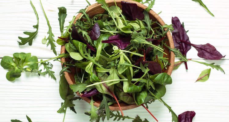 Fresh green salad with spinach ,ruccola,lettuce on wooden table.