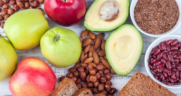 Healthy food - avokado, flax seeds, whole grain bread, nuts and apples on wooden background. Diet and healthy lifestyle concept. Vegetarian food