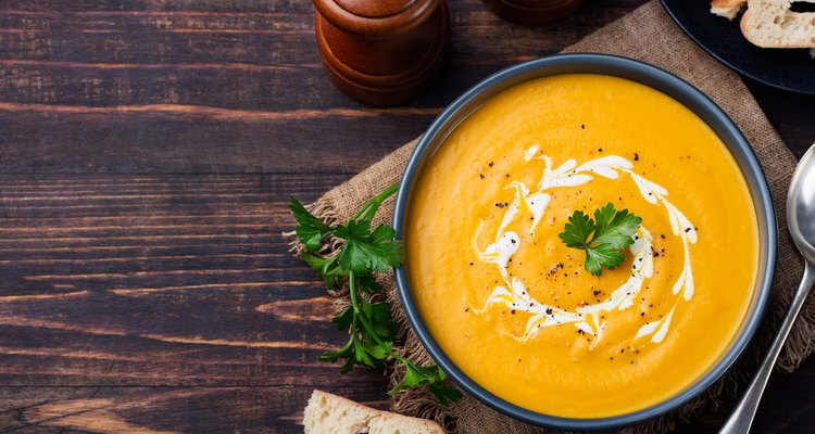 Pumpkin and carrot soup with cream and parsley