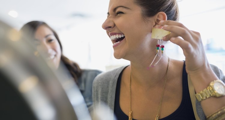 Laughing woman holding earrings in shop