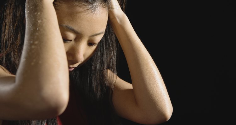 Sweaty Asian woman with hands in hair