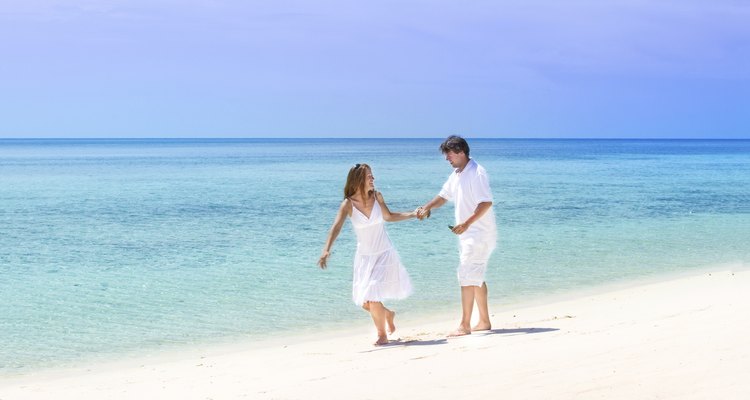 Beautiful young couple running on a tropical beach