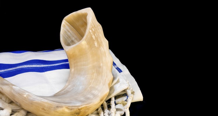 Rosh Hashanah Jewish New Year shofar,tallit. Isolated on black.