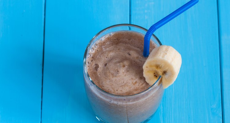 Chocolate milkshake smoothie in glass on blue wooden background