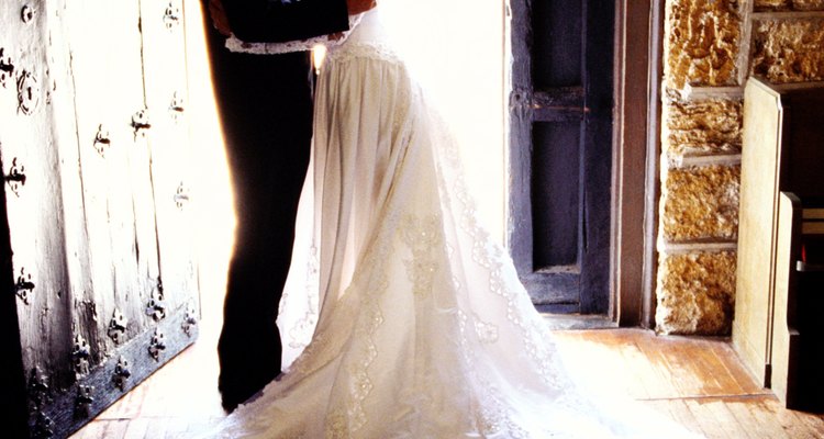 side view of a bride and groom holding each other at the entrance to the church