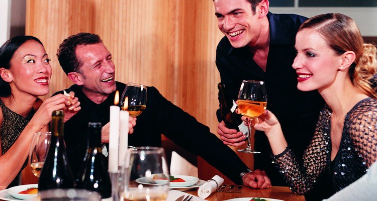 Host pouring wine for dinner guests