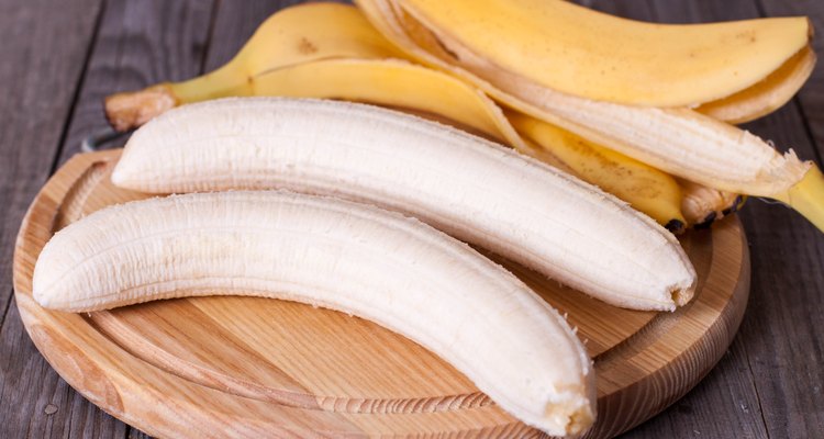 Peeled banana on a wooden board