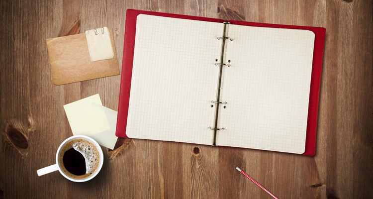 Workspace with coffee cup, note paper and notebook