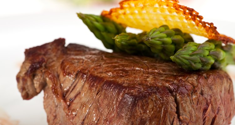 Nahaufnahme eines Rindersteaks mit grünem Spargel auf weiÃen Hintergrund