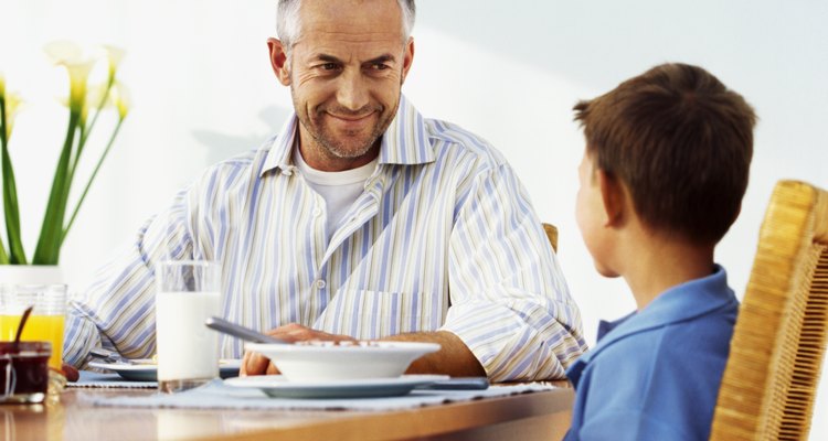 Close-up of father and son (10-11) having breakfast
