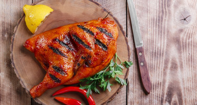 Grilled half chicken barbecue on a wooden surface