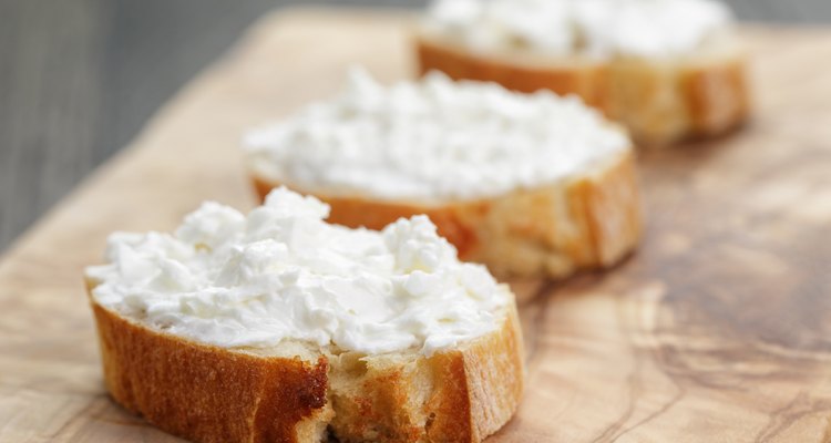 crunchy baguette slices with cream cheese on olive board