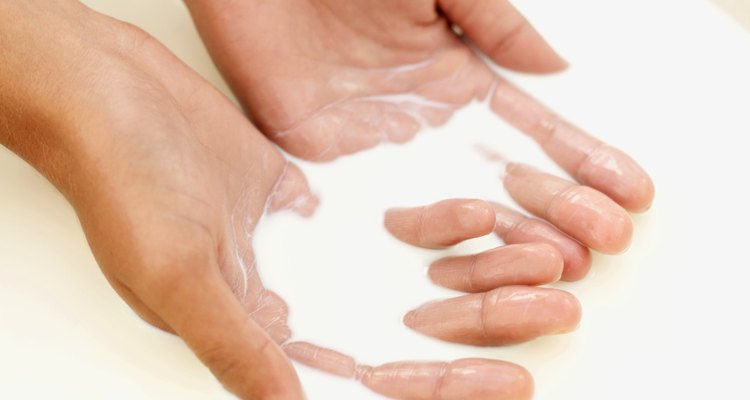 high angle view of a woman's hand immersed in milk
