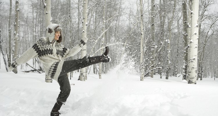 Mature woman playing in snow, smiling