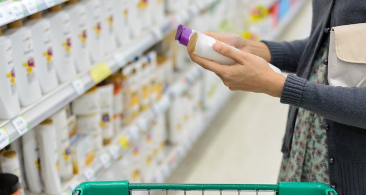 women comparing shampoo in supermarket