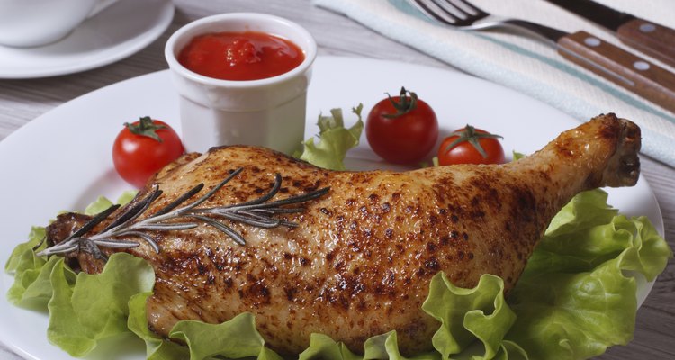 Fried chicken leg with rosemary, lettuce and tomato sauce