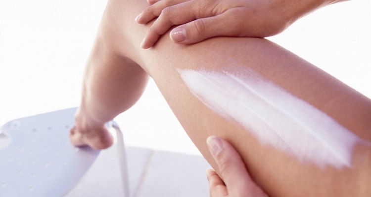 Woman applying lotion to leg