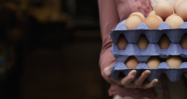 Woman holding trays of eggs, mid section, close-up