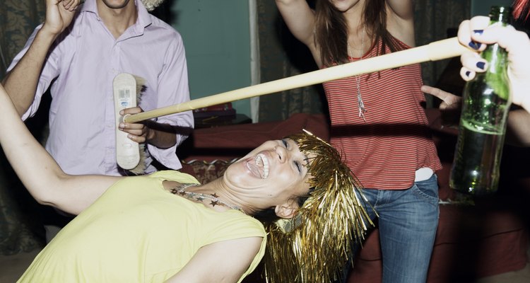 Friends playing game of limbo at house party