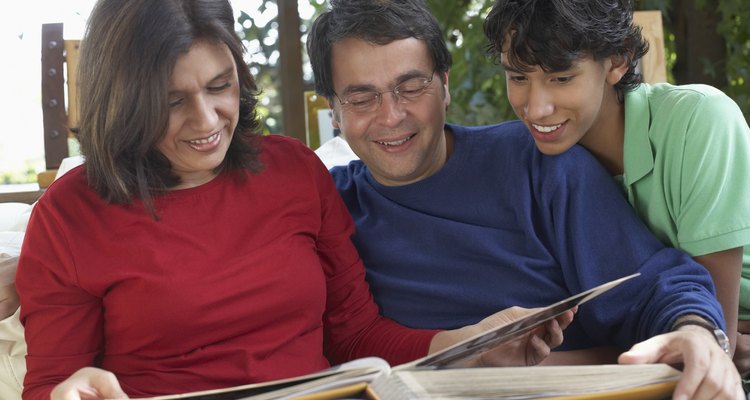 Close-up of a mature couple looking at photographs with their teenage son