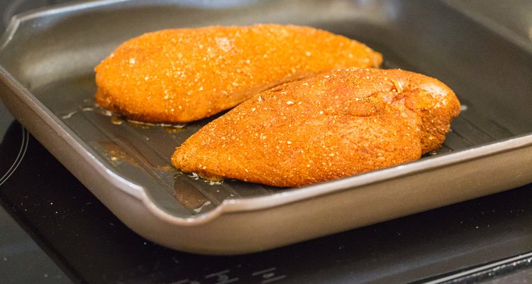 Two seasoned chicken breasts cooking