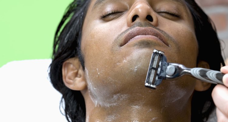 Shaving face of man