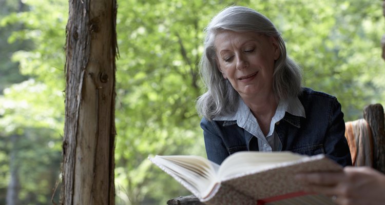mature woman watching photo album on porch