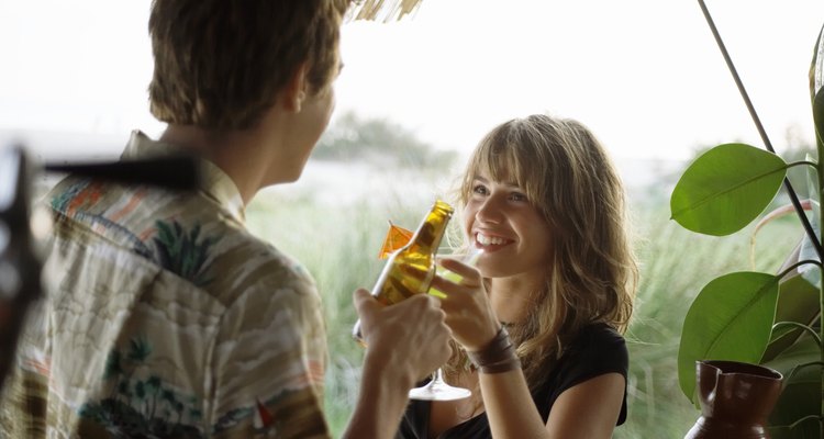 Young couple having drinks at beach bar, close-up