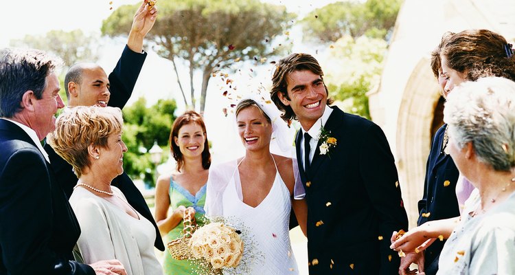 People Throwing Confetti Over a Newlywed Couple Leaving Church