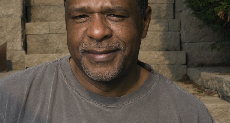 Portrait of mature man in t-shirt reading 'half full', smiling, outdoors