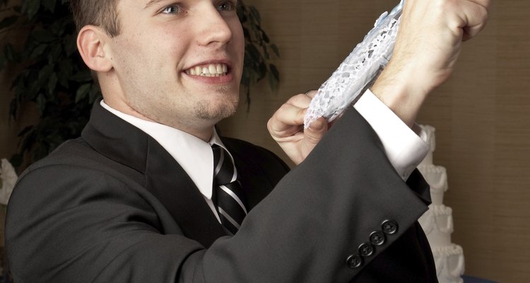Caucasian groom flipping a garter belt